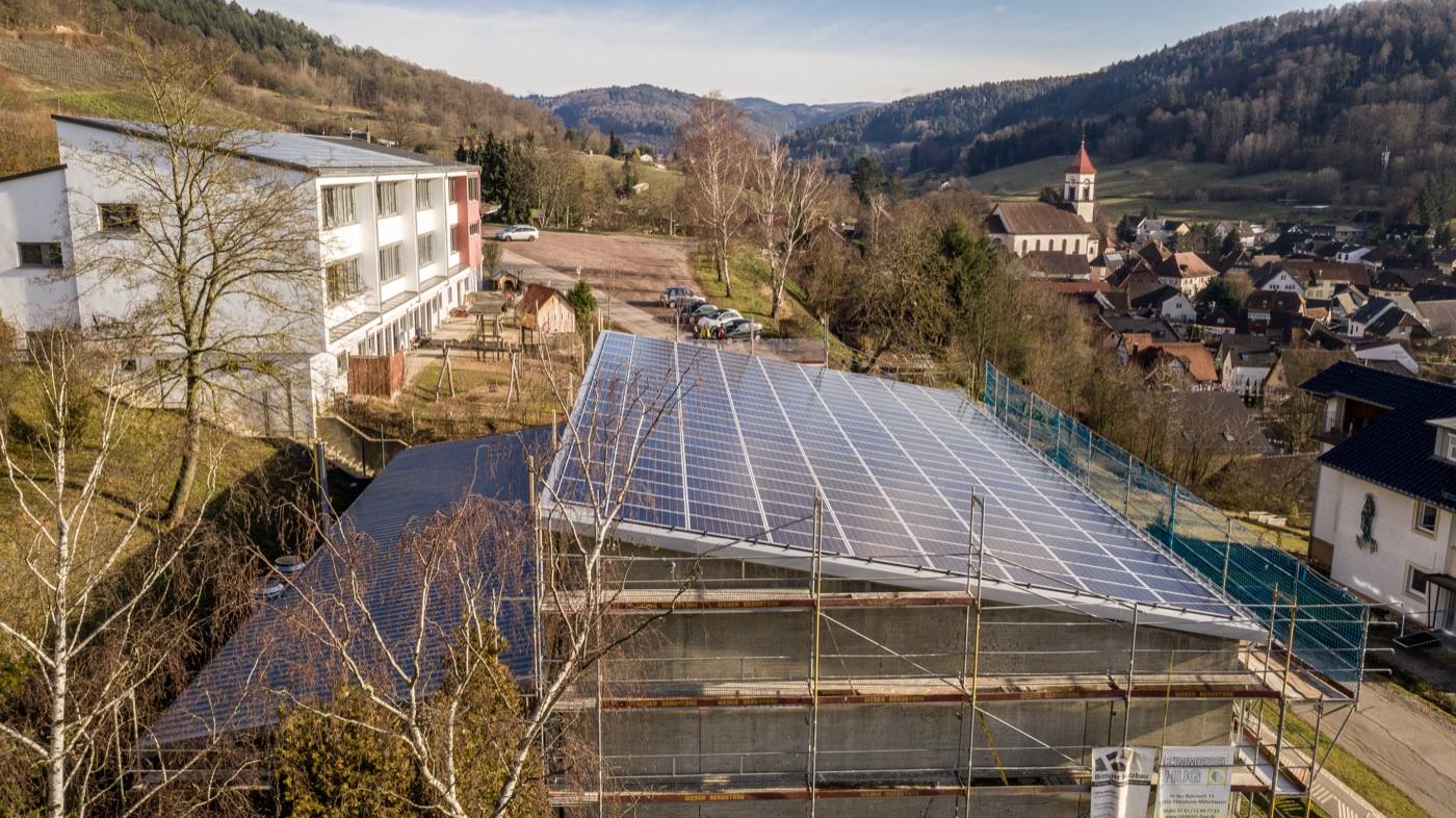 Photovoltaik-Dachanlage über einem Dorf im Schwarzwald