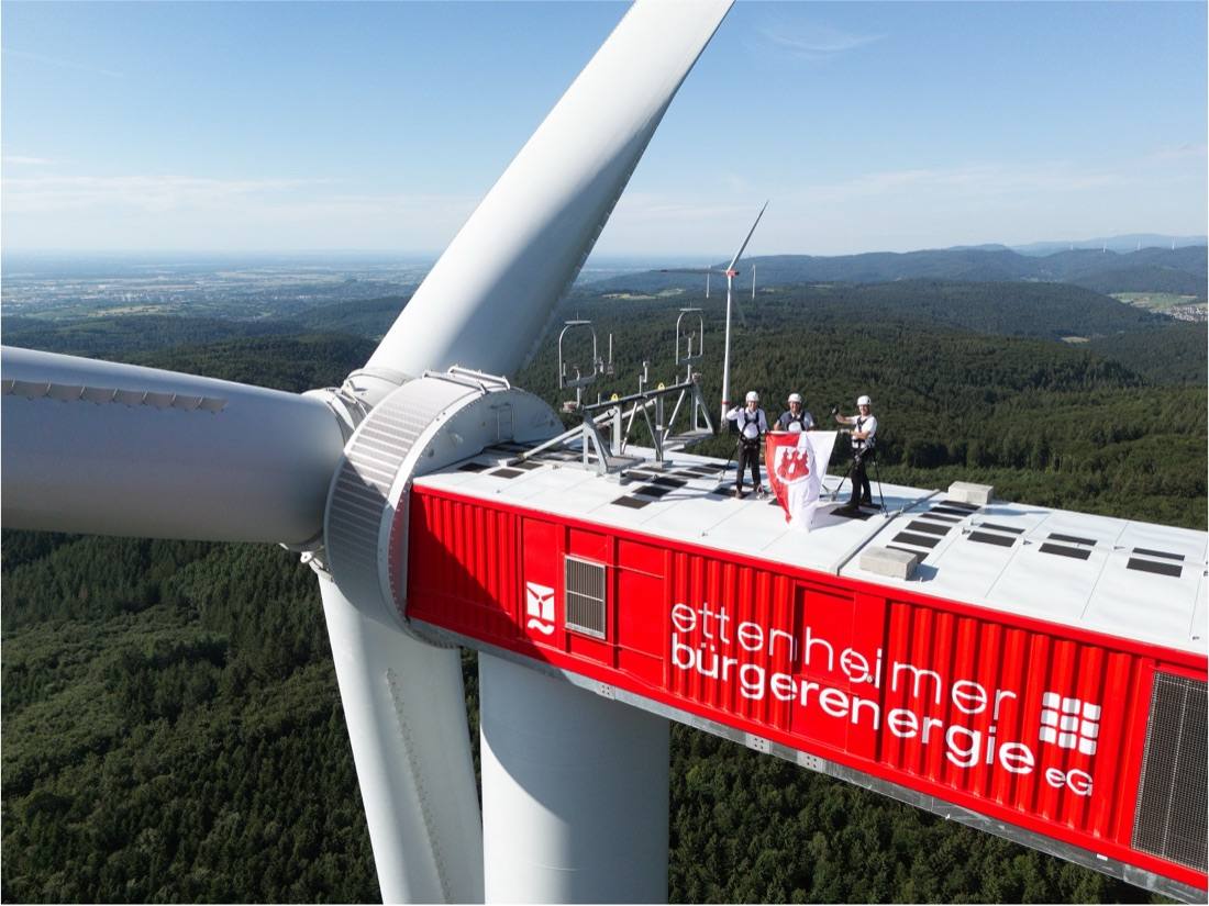 Menschen auf der Gondel einer Windenergieanlage